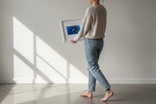 Load image into Gallery viewer, Woman carrying Manta Ray framed art print toward wall